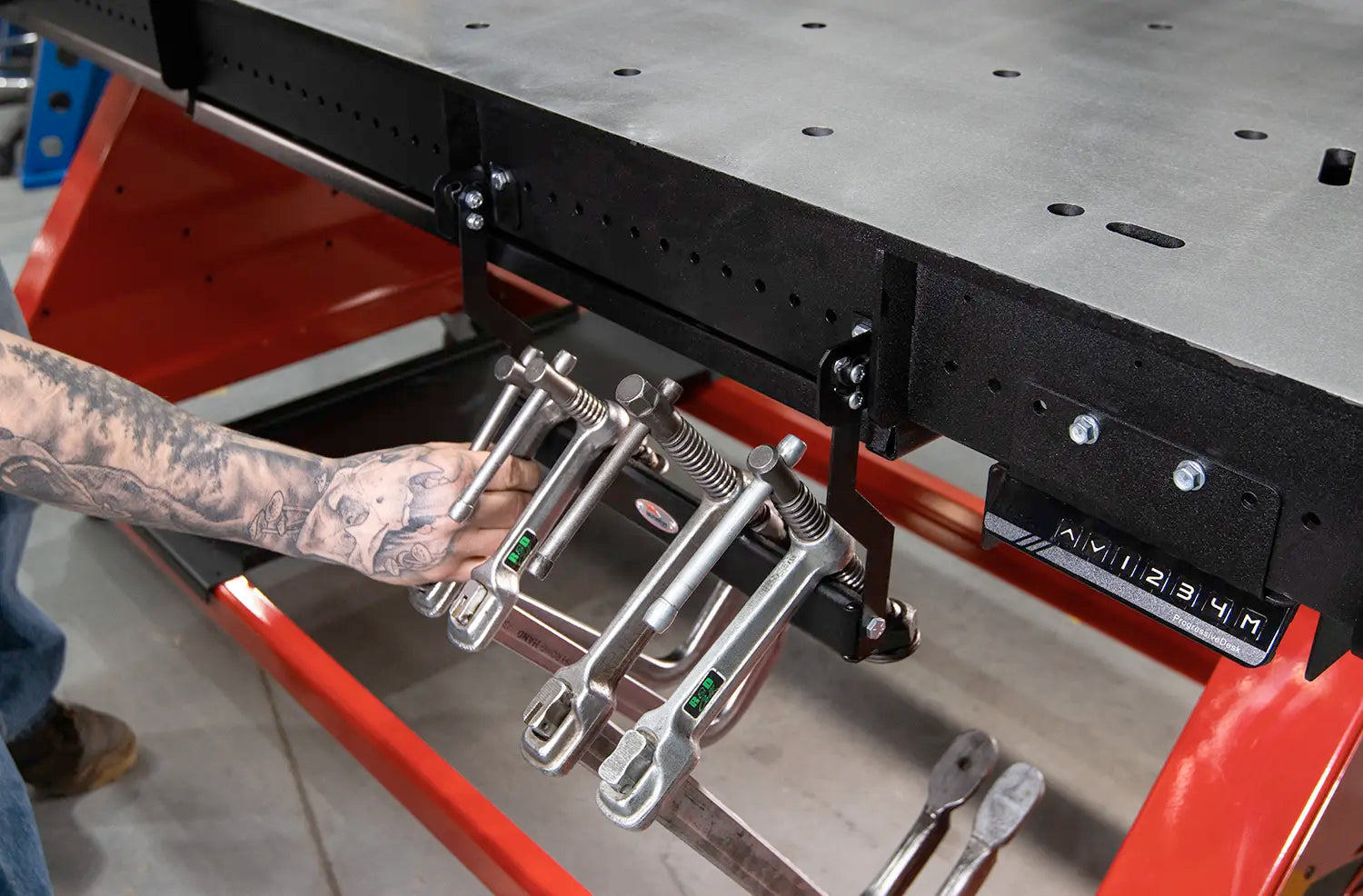 line up multiple heavy welding clamps on metal hanger